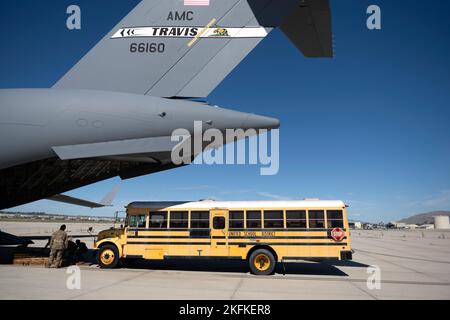 Un autobus scolaire s'approche d'un C-17 Globemaster III le 23 septembre 2022, à la base de réserve aérienne de mars, en Californie. Un équipage de réserve du 301st e Escadron de transport aérien a effectué une mission de trois jours du 23 au 25 septembre pour transporter du fret humanitaire en Haïti. Grâce au programme Denton, trois autobus scolaires donnés du district scolaire unifié de San Diego ont été transportés de l'ARB de mars à Haïti. Banque D'Images