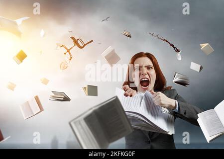 Jeune femme stressée déchirant des documents avec une expression faciale frustrée. Banque D'Images