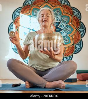 Femme senior, yoga et méditation dans le studio de fitness pour la santé du corps et la motivation de bien-être avec bol d'or et mandala. Spirituel, énergie et équilibre Banque D'Images