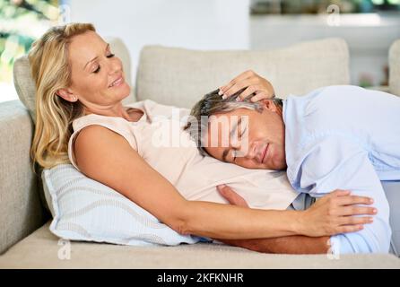 Véritable dévotion. Un couple mature partage un moment tendre ensemble tout en se relaxant à la maison. Banque D'Images