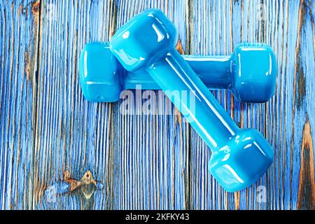 Haltères bleues sur bois d'époque. Banque D'Images