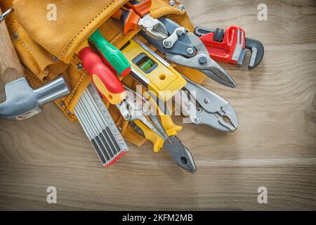 Outils de construction en ceinture à outils en cuir sur panneau de bois. Banque D'Images