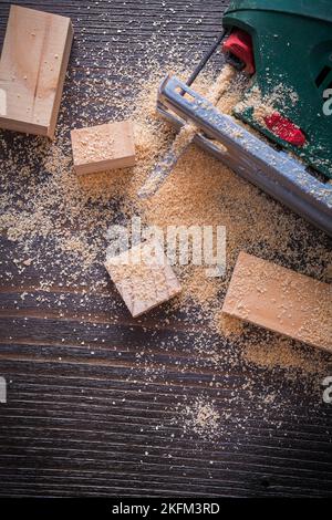 Scie sauteuse électrique sciure et planches en bois sur le concept de construction de bois d'époque. Banque D'Images