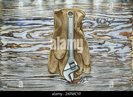 Gants de sécurité, clé réglable sur panneau en bois. Banque D'Images