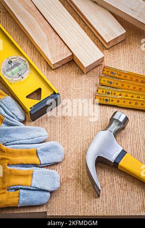 jeu d'outils de menuiserie marteau à griffes gants de protection compteur en bois construction planches de niveau sur panneau en bois Banque D'Images