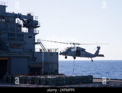 Un MH-60s Knighthawk, attaché aux « Tridents » de l'Escadron de combat en mer (HSC) 9, arrive au navire de fret et de munitions USNS Medgar Evers (T-AKE 13) pendant une munition en charge avec le premier porte-avions de la catégorie USS Gerald R. Ford (CVN 78), le 26 septembre 2022. Ford est en cours dans l'océan Atlantique en vue d'un déploiement prévu cet automne. Banque D'Images