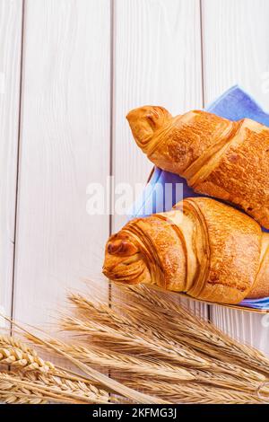 deux croissants et épis de blé sur des planches peintes en blanc Banque D'Images