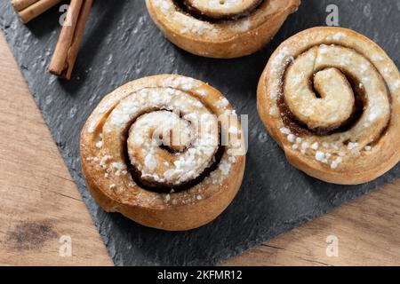 Petits pains à la cannelle sur une table en bois. Dessert suédois Kanelbulle Banque D'Images