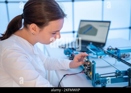 concevoir le développement d'un dispositif pour une expérience physique l'étude de matériaux solides une jeune femme élève développe un logiciel Banque D'Images