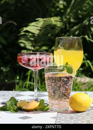 Cocktails rafraîchissants sur une table de jardin. Gros plan des verres avec différentes boissons. Faites la fête dans un jardin. Banque D'Images