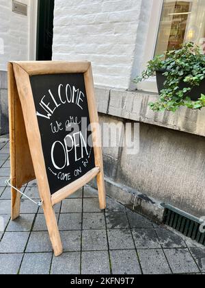 panneau en face d'une boutique ou d'un café. tableau de craie avec panneau ouvert à la rue, l'entrée d'un magasin dit bienvenue, nous sommes ouverts venez sur le boa noir Banque D'Images