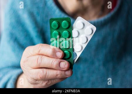 Une femme âgée, une grand-mère, tient des médicaments, des pilules, des médicaments dans sa main de près Banque D'Images