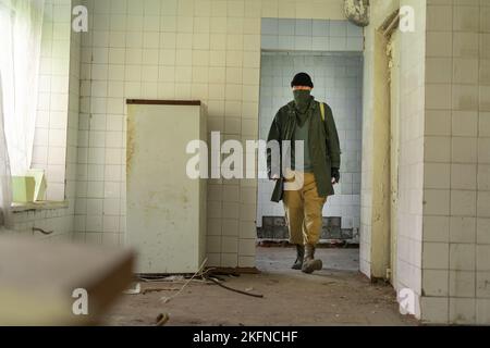 Après l'apocalypse. Homme voyageant à pied dans un monde post-apocalyptique recherche de nourriture sur des bâtiments abandonnés. Copier l'espace Banque D'Images