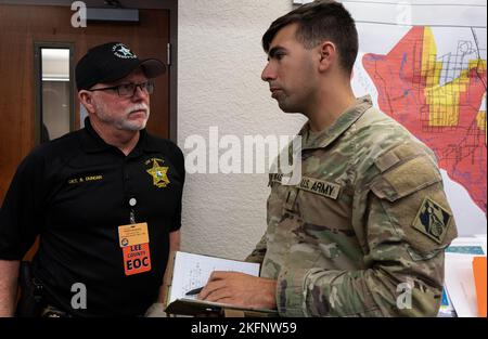 1lt. John E. Nikas, ingénieur de projet, et l'aide du colonel, s'entretient avec le détective S. Duncan, bureau du shérif du comté de Lee. Le U.S. Army corps of Engineers (USACE) travaille en partenariat avec la réponse locale, nationale et fédérale à l'ouragan Ian. Plus de 800 employés et sous-traitants de l'USACE sont déployés et engagés, en coordination avec des partenaires locaux, nationaux et fédéraux dans les zones touchées. Notre priorité numéro un reste la vie, la santé et la sécurité de tous les intervenants touchés par l'ouragan Ian. Banque D'Images