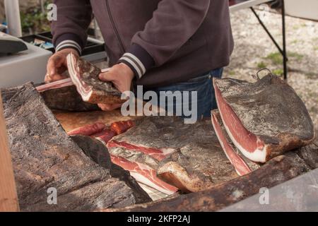 Filet de speck fumé traditionnel sur place lors d'une célébration à Val di Funes, Dolomites. Banque D'Images