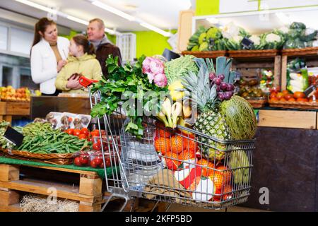 Chariot complet dans le magasin de légumes Banque D'Images