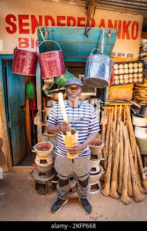 Un homme se tenant à l'extérieur de son magasin de matériel dans le marché de Mzuzu, au Malawi Banque D'Images