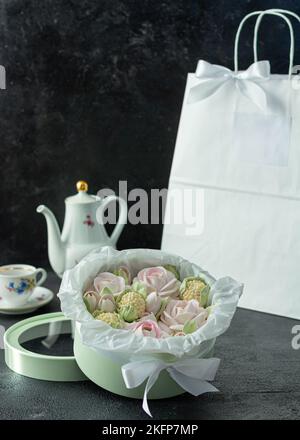 Un bouquet de fleurs de zephyr - guimauves dans une belle boîte sur fond sombre soirée thé fête Banque D'Images