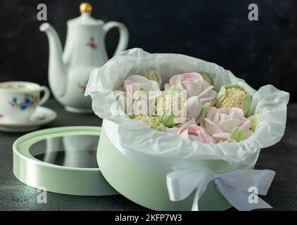 Un bouquet de fleurs de zephyr - guimauves dans une belle boîte sur fond sombre soirée thé fête Banque D'Images