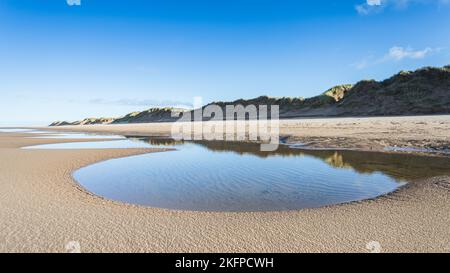 Une chaîne de bassins de marée vus sur la plage de Formby reflétant les dunes de sable qui bordent la plus grande partie du littoral de Sefton entre Liverpool et Southport. Banque D'Images