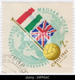 HONGRIE - 1962 21 mai : un timbre de poste aérien de 2 forints de verdâtre représentant le Globe, le ballon de football et les drapeaux de Hongrie et de Grande-Bretagne. Drapeaux aux couleurs nationales. Championnat du monde de football, Chili, 30 mai... 17 juin. Au total, 56 équipes ont participé aux phases de qualification de la coupe du monde de la FIFA 1962, se disputant un total de 16 places dans le tournoi final. Le Chili, en tant que pays hôte, et le Brésil, en tant que champions défendeurs, se sont automatiquement qualifiés, laissant 14 places ouvertes à la compétition Banque D'Images