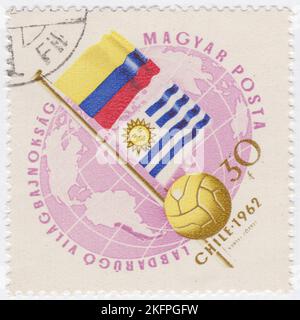 HONGRIE - 1962 21 mai : timbre-poste de 30 forints représentant le Globe, le ballon de football et les drapeaux de Colombie et d'Uruguay. Drapeaux aux couleurs nationales. Championnat du monde de football, Chili, 30 mai... 17 juin. Au total, 56 équipes ont participé aux phases de qualification de la coupe du monde de la FIFA 1962, se disputant un total de 16 places dans le tournoi final. Le Chili, en tant que pays hôte, et le Brésil, en tant que champions défendeurs, se sont automatiquement qualifiés, laissant 14 places ouvertes à la compétition Banque D'Images