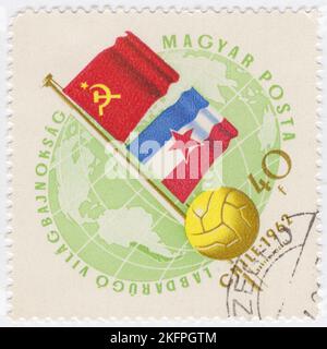 HONGRIE - 1962 21 mai : un timbre-poste de 40 forints vert pâle et de bister représentant le Globe, le ballon de football et les drapeaux de l'URSS et de la Yougoslavie. Drapeaux aux couleurs nationales. Championnat du monde de football, Chili, 30 mai... 17 juin. Au total, 56 équipes ont participé aux phases de qualification de la coupe du monde de la FIFA 1962, se disputant un total de 16 places dans le tournoi final. Le Chili, en tant que pays hôte, et le Brésil, en tant que champions défendeurs, se sont automatiquement qualifiés, laissant 14 places ouvertes à la compétition Banque D'Images