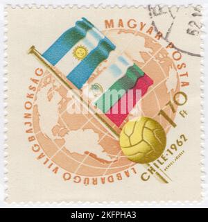 HONGRIE - 1962 21 mai : timbre-poste de 1,70 ans à l'ocre et à la bister représentant le Globe, le ballon de football et les drapeaux de l'Argentine et de la Bulgarie. Drapeaux aux couleurs nationales. Championnat du monde de football, Chili, 30 mai... 17 juin. Au total, 56 équipes ont participé aux phases de qualification de la coupe du monde de la FIFA 1962, se disputant un total de 16 places dans le tournoi final. Le Chili, en tant que pays hôte, et le Brésil, en tant que champions défendeurs, se sont automatiquement qualifiés, laissant 14 places ouvertes à la compétition Banque D'Images