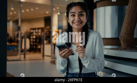 Happy girl Woman acheteur shopping en ligne à l'application mobile gagner des remises entreprise bénéfice célébrer la réalisation faire les pouces vers le haut geste recommander téléphone moderne Banque D'Images