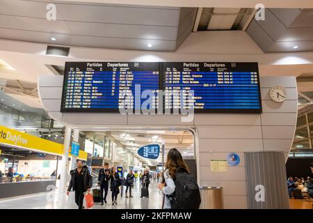 Une jeune femme debout avec son sac à dos regarde l'horaire à la gare de l'aéroport. Transports en commun à thème. Banque D'Images