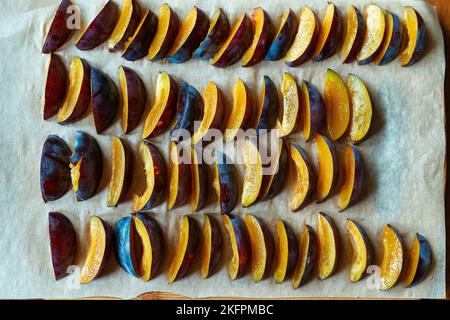 Des prunes en tranches sont disposées pour la congélation. Banque D'Images