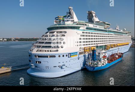Estonie, Tallinn - 21 juillet 2022 : le pétrolier Blue Ristna fait le plein de Voyager blanc des mers, navire de croisière Royal caribbean amarré dans le port sous le ciel bleu Banque D'Images