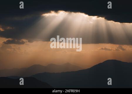 Poutres de soleil sur des contreforts de l'Himalaya silhouettés, au sud de la chaîne Annapurna. Népal. Banque D'Images