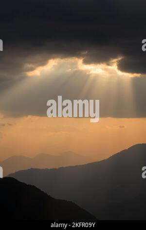 Poutres de soleil sur des contreforts de l'Himalaya silhouettés, au sud de la chaîne Annapurna. Népal. Banque D'Images