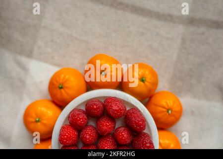 Gros plan sur les framboises et les mandarines. Les fruits sont bons pour la santé. Une alimentation adéquate, des aliments crus. Aliments biologiques. Banque D'Images
