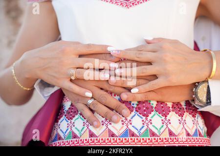 Gros plan d'un homme qui embrasse sa femme enceinte de derrière les mains en contact Banque D'Images