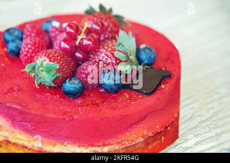 Fantastique gâteau à Paris (au spectacle) avec garniture de fruits : fraises, framboises, bleuets et raisins rouges et un morceau de chocolat (rouge Banque D'Images