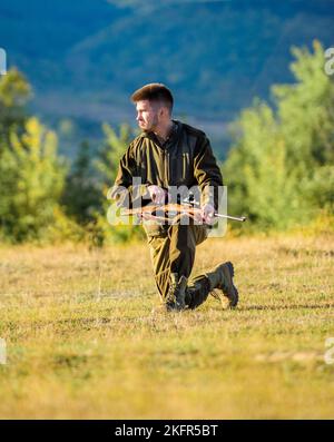 Trophée de chasse. Chasseur avec fusil à la recherche d'animaux. Homme chargeant le fusil de chasse. Chasse comme loisir et passe-temps masculin. Vêtements kaki Hunter Banque D'Images