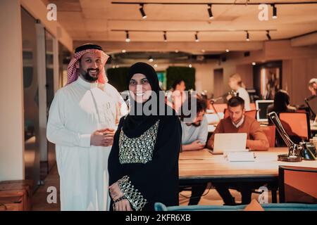 Photo portrait d'un homme d'affaires arabe dirigeant avec une hijab musulmane discutant de projets d'affaires tout en utilisant des tablettes et un smartphone dans un verre moderne Banque D'Images