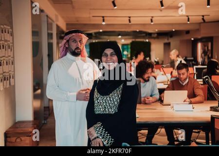 Photo portrait d'un homme d'affaires arabe dirigeant avec une hijab musulmane discutant de projets d'affaires tout en utilisant des tablettes et un smartphone dans un verre moderne Banque D'Images