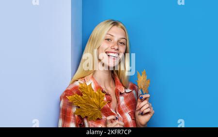 Fille d'automne. Femme souriante en tenue décontractée avec des feuilles jaunes. Tendances de la mode pour l'automne. Banque D'Images