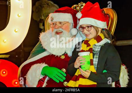 Une petite fille est assise sur les genoux du Père Noël pendant l’éclairage des arbres de Noël de la ville au parc Mardi gras, 18 novembre 2022, à Mobile, Alabama. Banque D'Images