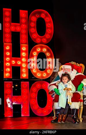 Une petite fille est assise sur les genoux du Père Noël pendant l’éclairage des arbres de Noël de la ville au parc Mardi gras, 18 novembre 2022, à Mobile, Alabama. Banque D'Images