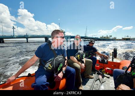 ADM. Arrière Brendan C. McPherson, commandant du septième district de la Garde côtière, parle avec le personnel de la Garde côtière à bord d'un bateau d'eau peu profonde à Matlacha Isles, en Floride, des équipes ont été mises en scène pour aider les gens de la communauté de Pine Island, qui ont été bloqués en raison de l'ouragan Ian le 4 octobre 2022. La Garde côtière a transféré plus de 700 personnes et biens essentiels à l'île. Banque D'Images