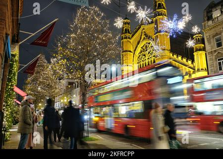 Londres, Royaume-Uni. 19th novembre 2022. Les bus passent devant Sloane Street et les lumières de Noël scintillent derrière vous. L'allumage de la lumière de Noël dans King's Road a attiré un grand nombre de visiteurs dans les environs, tandis que les gens entrent dans l'esprit festif. Crédit : onzième heure Photographie/Alamy Live News Banque D'Images