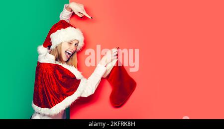 Femme drôle de wencking avec boule de noël. Jolie fille fêtez les vacances d'hiver sur fond rouge isolé Jeune fille belle avec boule de noël Banque D'Images