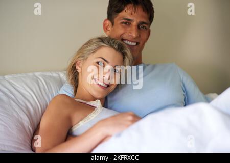 Mon côté est à ses côtés. Portrait d'un jeune couple allongé au lit. Banque D'Images