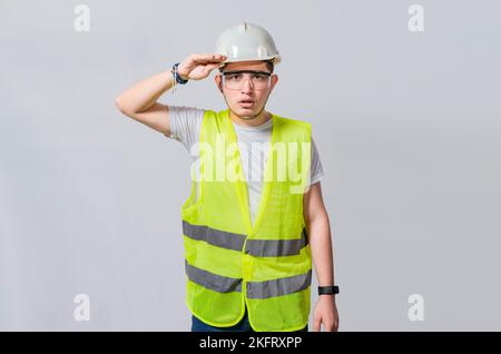Beau ingénieur regardant dans la distance isolée, jeune ingénieur regardant quelque chose dans la distance isolée, ingénieur constructeur regardant dans certains Banque D'Images