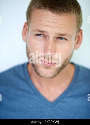 Il garde son style simple. Studio photo d'un beau jeune homme posant sur un fond blanc. Banque D'Images