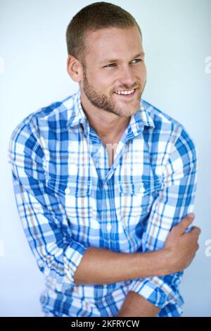 La positivité ne se déporte jamais du style. Studio photo d'un beau jeune homme posant sur un fond blanc. Banque D'Images